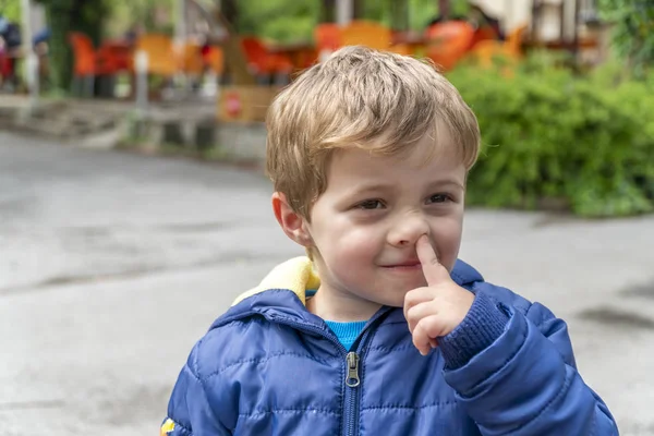 Small child picking his nose and making faces