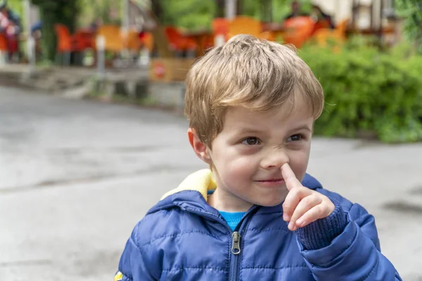 Small child picking his nose and making faces
