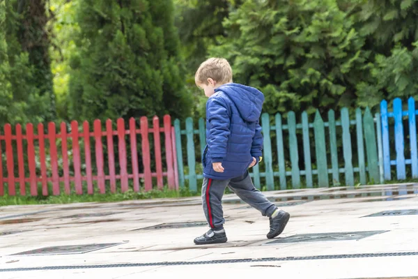 Kleines Kind kratzt sich im Park am Po — Stockfoto