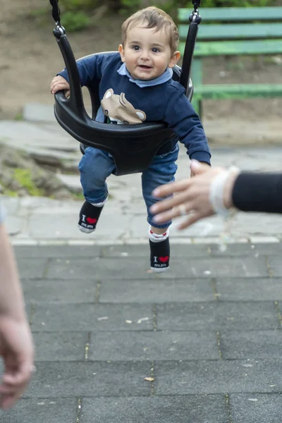 Lächelnder kleiner Junge auf einer Kinderschaukel — Stockfoto