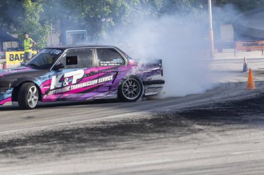 Bir pistte araba sürüklenen yarış Yarışması