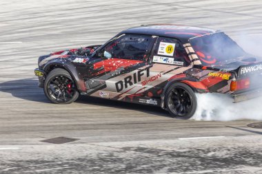 Bir pistte araba sürüklenen yarış Yarışması