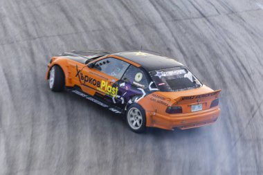 Bir pistte araba sürüklenen yarış Yarışması