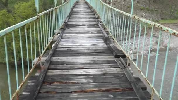 Caminhando sobre uma ponte suspensa antiga e perigosa — Vídeo de Stock