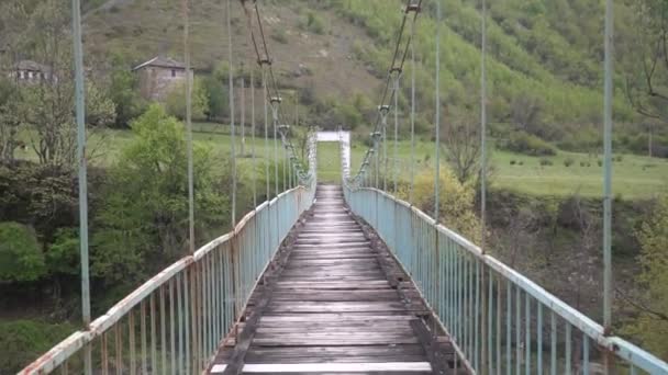 Прогулка по старому и опасному подвешенному мосту — стоковое видео