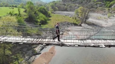 Asma köprüden geçen bir kişinin havadan görünümü