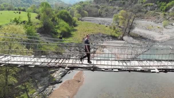 Vista aerea di una persona che attraversa un ponte sospeso — Video Stock