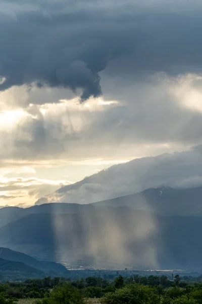 Sunbeams peaking through the clouds and lighting the Rose valley in Bulgaria