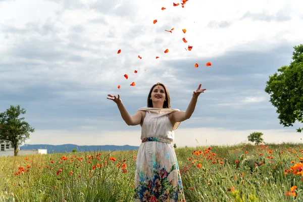 Ung Kvinna Vit Klänning Kastar Röda Vallmo Blommor Kameran — Stockfoto