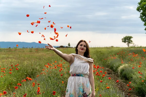 Jeune Femme Dans Une Robe Blanche Jetant Des Fleurs Pavot — Photo