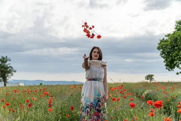 Jeune Femme Dans Une Robe Blanche Jetant Des Fleurs Pavot — Photo