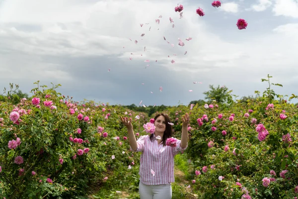 Ung Kvinna Kastar Bulgariska Rosa Rosor Trädgård Med Vackra Moln — Stockfoto