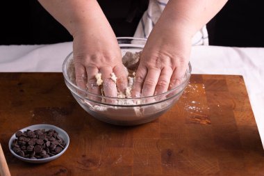 Kafkasyalı kadın ellerinde çikolatalı kurabiye hamuru yoğuruyor.