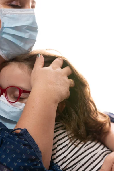 Kadın Coronavirus 'tan muzdarip kızı maskeyle rahatlatıyor, saçlarına dokunuyor.