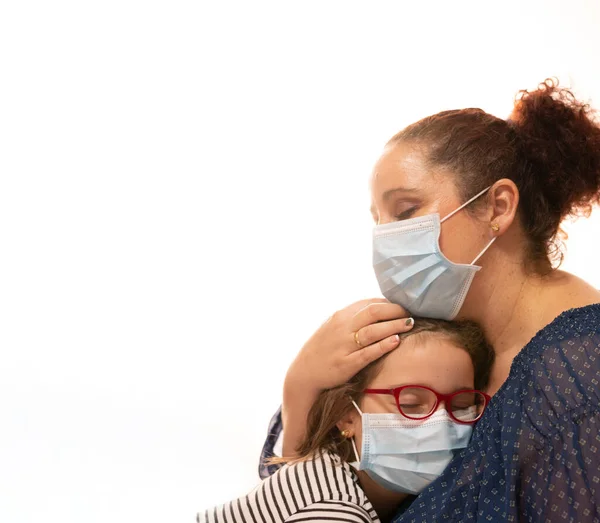 Kadın Coronavirus 'tan muzdarip kızı maskeyle rahatlatıyor, saçlarına dokunuyor.