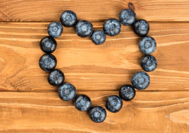 Taze yaban mersini ile kaplı ahşap arka plan, üstten görünüm üzerinde kalp şeklinde