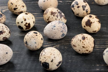 Koyu ahşap arka plan üzerinde dağınık çiğ bıldırcın yumurtası