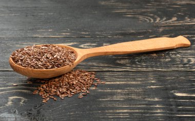 Kaşık keten tohumu ve masanın üzerinde dağınık tahıl ile