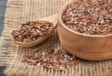 Bir kase ve çul portre üzerinde dağınık fasulyeli kaşığı keten tohumu