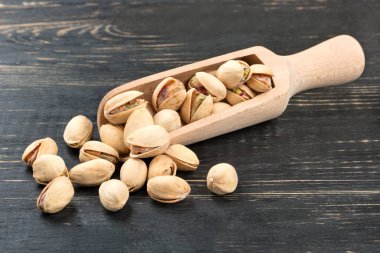 Bir kepçe ve karanlık bir tablo üzerinde dağınık fındık fıstık