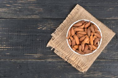 Özbek badem kase bir çuval bezi ve ahşap arka plan üzerinde Üstten Görünüm