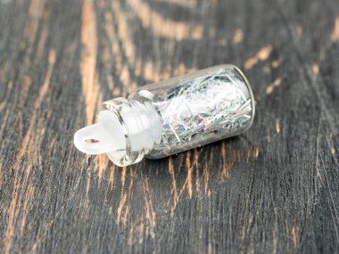 Şişe tırnak tasarım ahşap arka plan üzerinde gümüş pullu