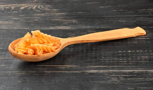 Bir Tahta Kaşık Karanlık Tablo Içinde Pişmemiş Makarna Düdük — Stok fotoğraf