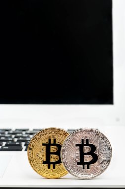 Altın ve gümüş paralar bitcoin beyaz bir laptop