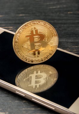 Altın sikke Smartphone cep telefonu ile yakından Bitcoin