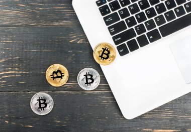 Gümüş ve altın sikkeler bitcoin tablo, üstten görünüm üzerinde bir dizüstü bilgisayar ile