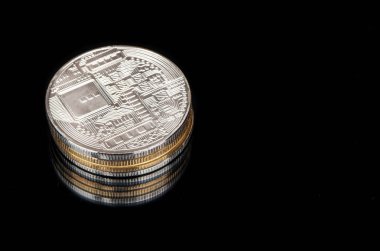 Bitcoin siyah zemin üzerine altın ve gümüş sikke yığını