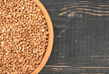 Bir karanlık masa üstü görünümde Ham buğday bir kase parçası