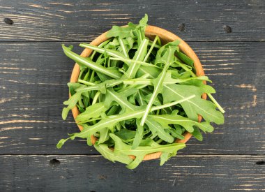 Yeşil roka kapta ahşap arka planda, üstten görünüm bırakır.