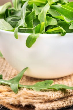 Bir kase taze roka yaprakları üzerine çuval bezi portre