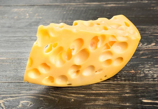 Stück Käse Mit Löchern Auf Einem Hölzernen Hintergrund — Stockfoto