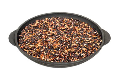 Beyaz arka plan üzerinde izole bir tavada çiğ siyah pirinç