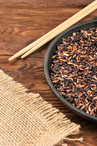 Parte Sartén Con Arroz Salvaje Negro Palillos Sobre Fondo Madera — Foto de Stock