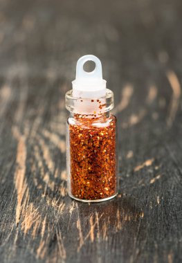 Tırnak tasarım ahşap arka plan üzerinde küçük bir şişe içinde parıltı