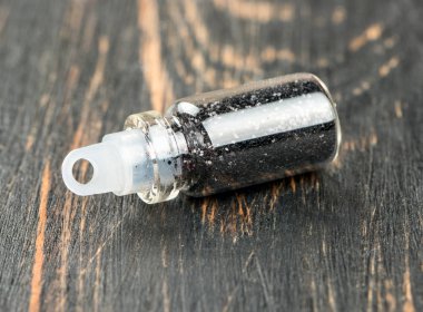 Tırnak tasarım ve makyaj ahşap arka plan üzerinde siyah pırıltılar