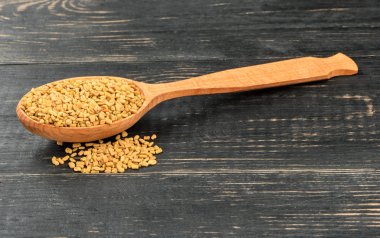 Çemen otu tohumu bir kaşık karanlık bir tablo içinde