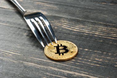 Altın bitcoin sikke ahşap zemin üzerine çatal ile