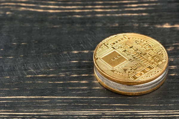 Stack of gold and silver coins to an empty wooden background