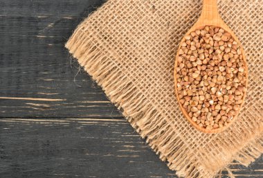 Yas ve boş ahşap arka plan üzerinde Ham buğday kaşığı