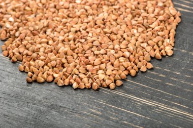 Karabuğday ahşap arka plan üzerinde dağınık çiğ taneleri