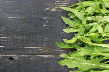 Boş ahşap arka plan üzerinde üstten görünüm taze roka yaprakları