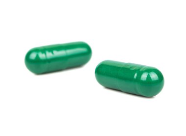 Beyaz arka plan üzerinde izole iki yeşil bitkisel kapsül