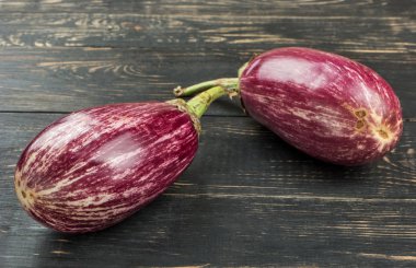 Ahşap arka plan üzerinde iki çiğ mor patlıcan