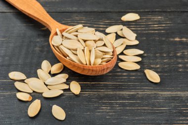 Kabuk ve kaşık ahşap arka plan üzerinde kabak çekirdeği