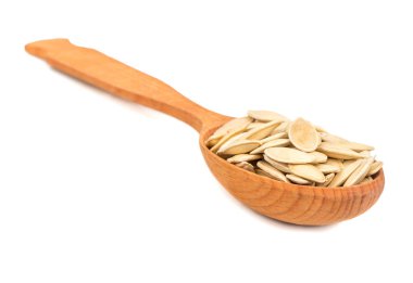 Tahta kaşık beyaz arka plan üzerinde kavrulmuş kabak çekirdeği