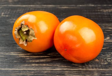 Ahşap arka plan üzerinde iki Olgun hurma meyve